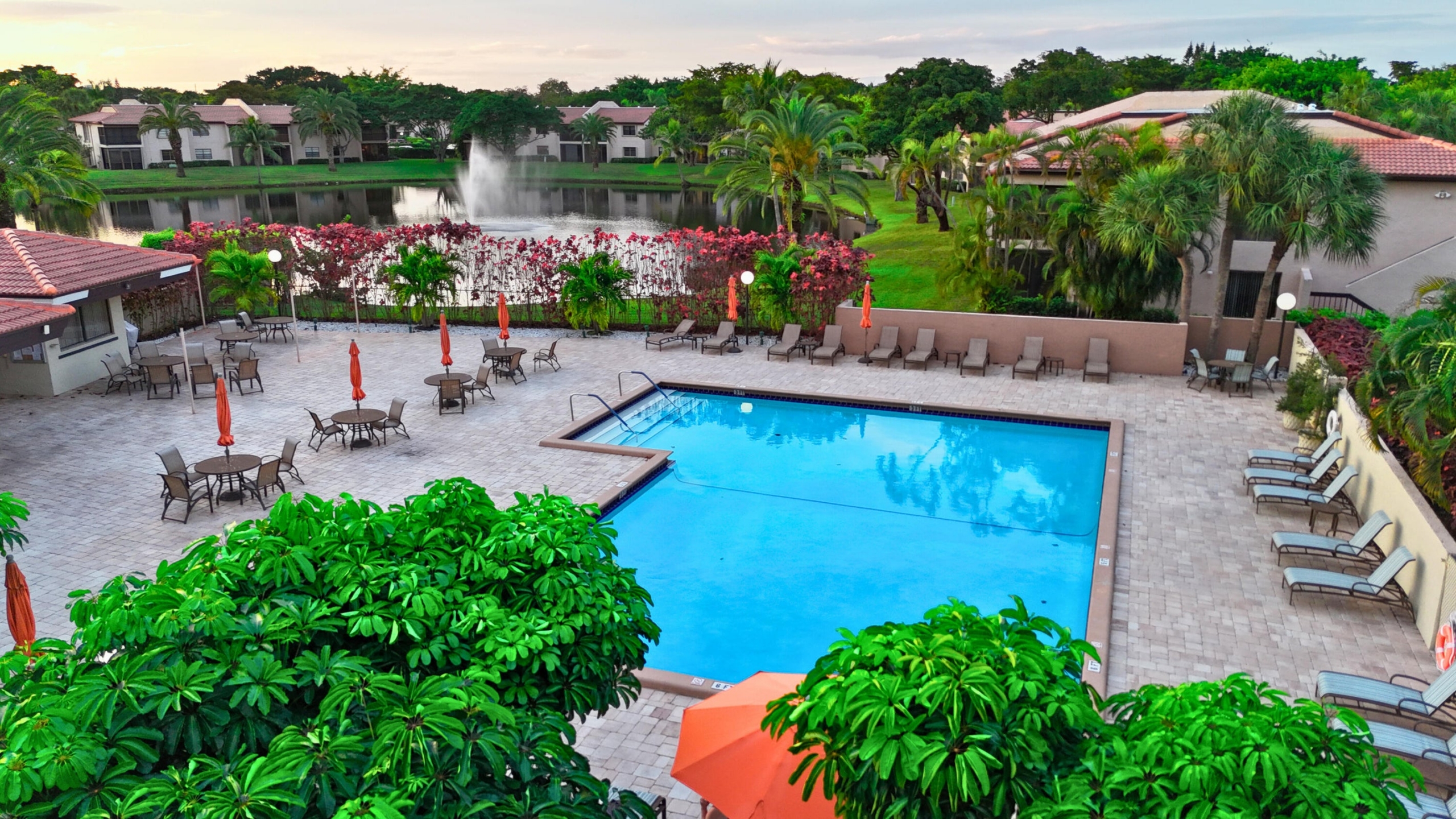 Community pool overlooking a lake and fountain in Boca Raton, Florida